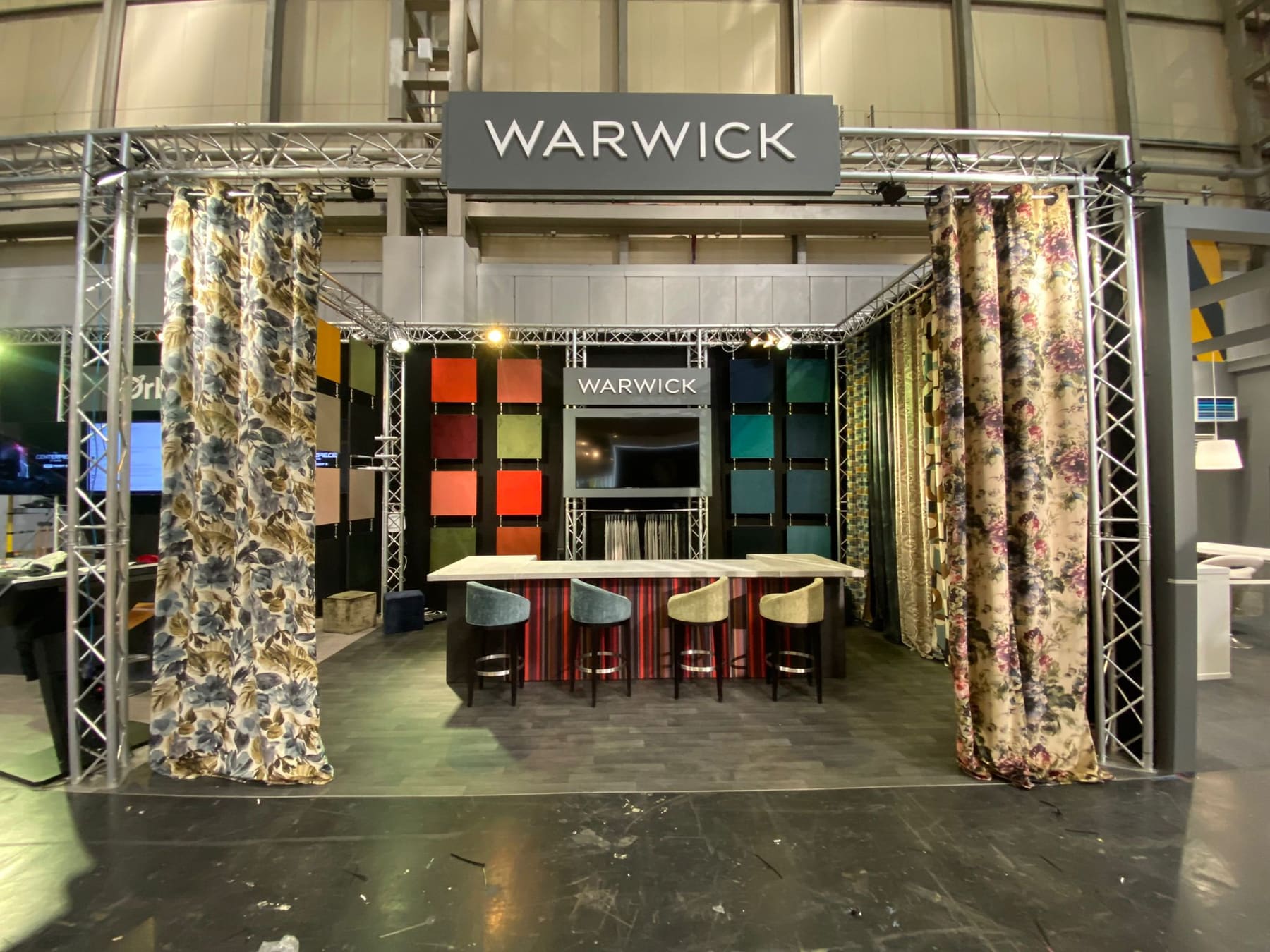 Modular exhibition stand with fabric drapes and display counters